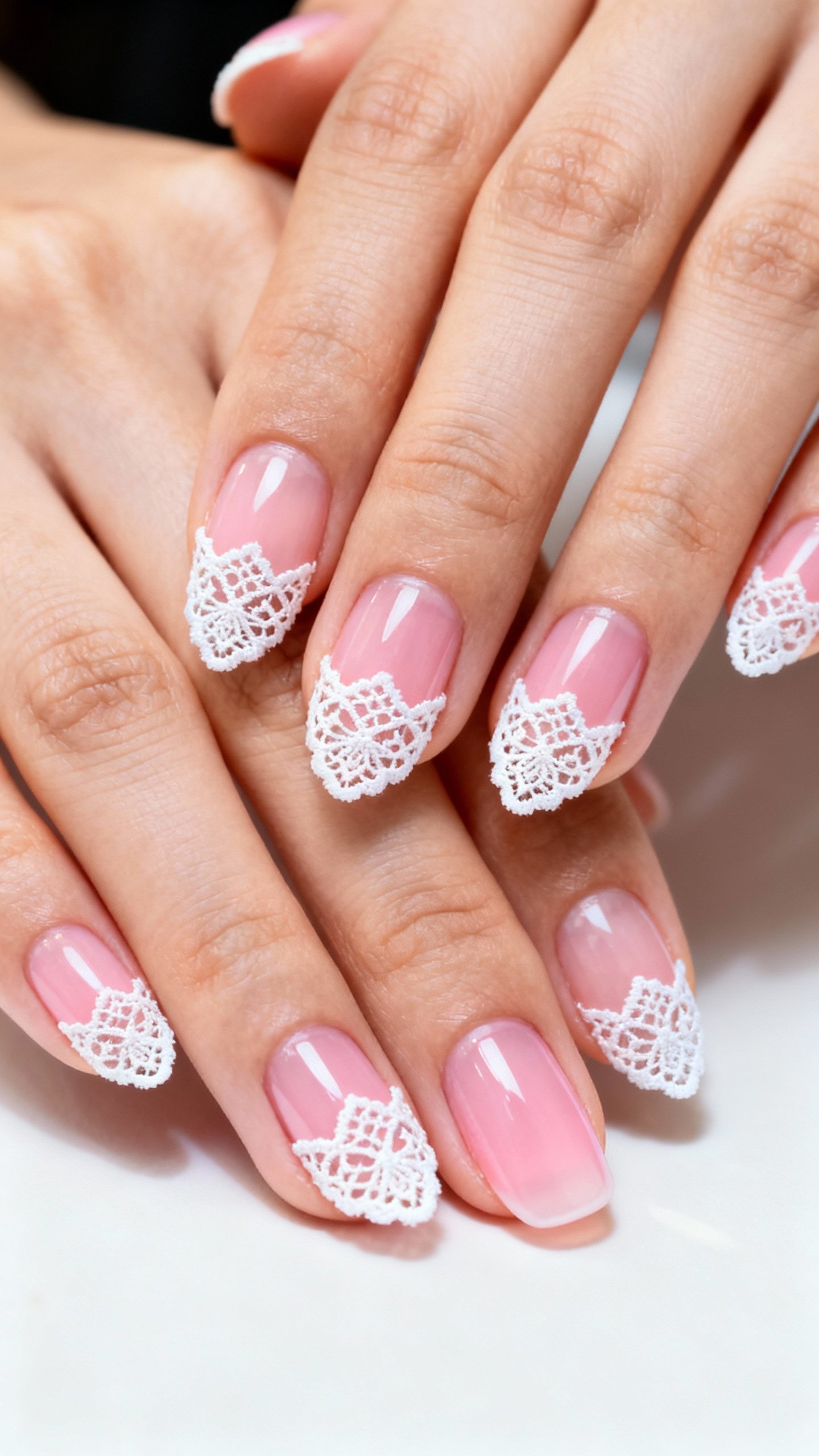 Closeup female hands, sheer pink base, white lace cuticle crowns