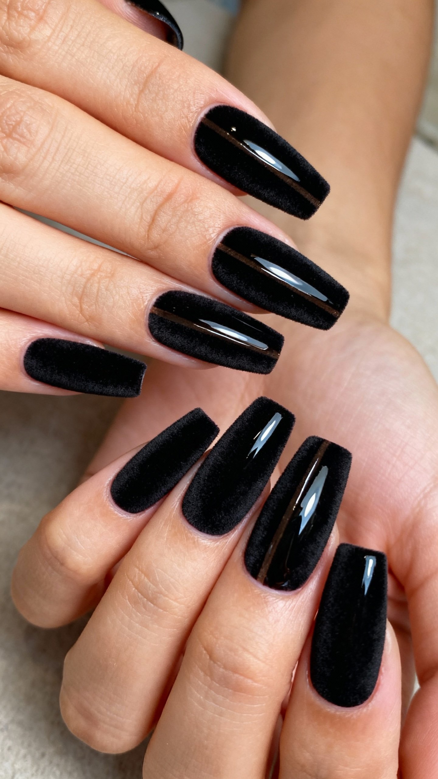 Closeup female hands with velvet-matte black coffin nails, glossy center stripe