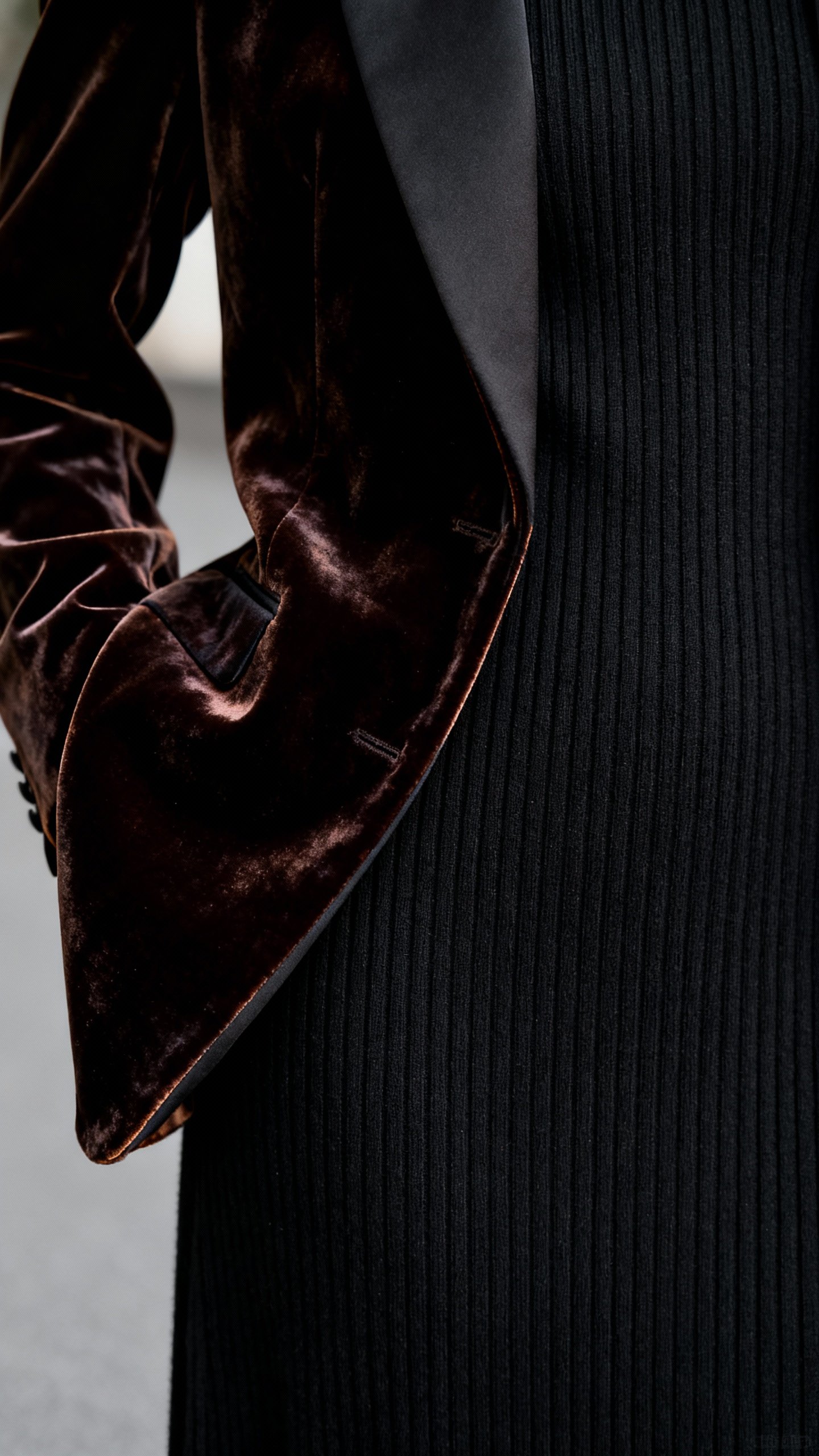 Closeup of velvet blazer lapel over black knit dress