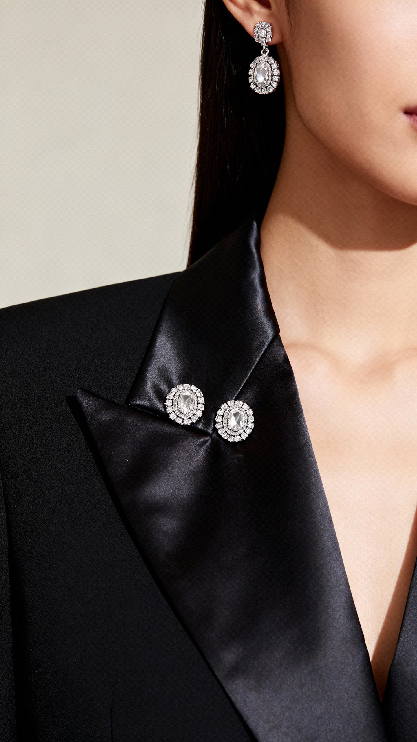Closeup satin peak lapels on black tuxedo blazer, jeweled earrings