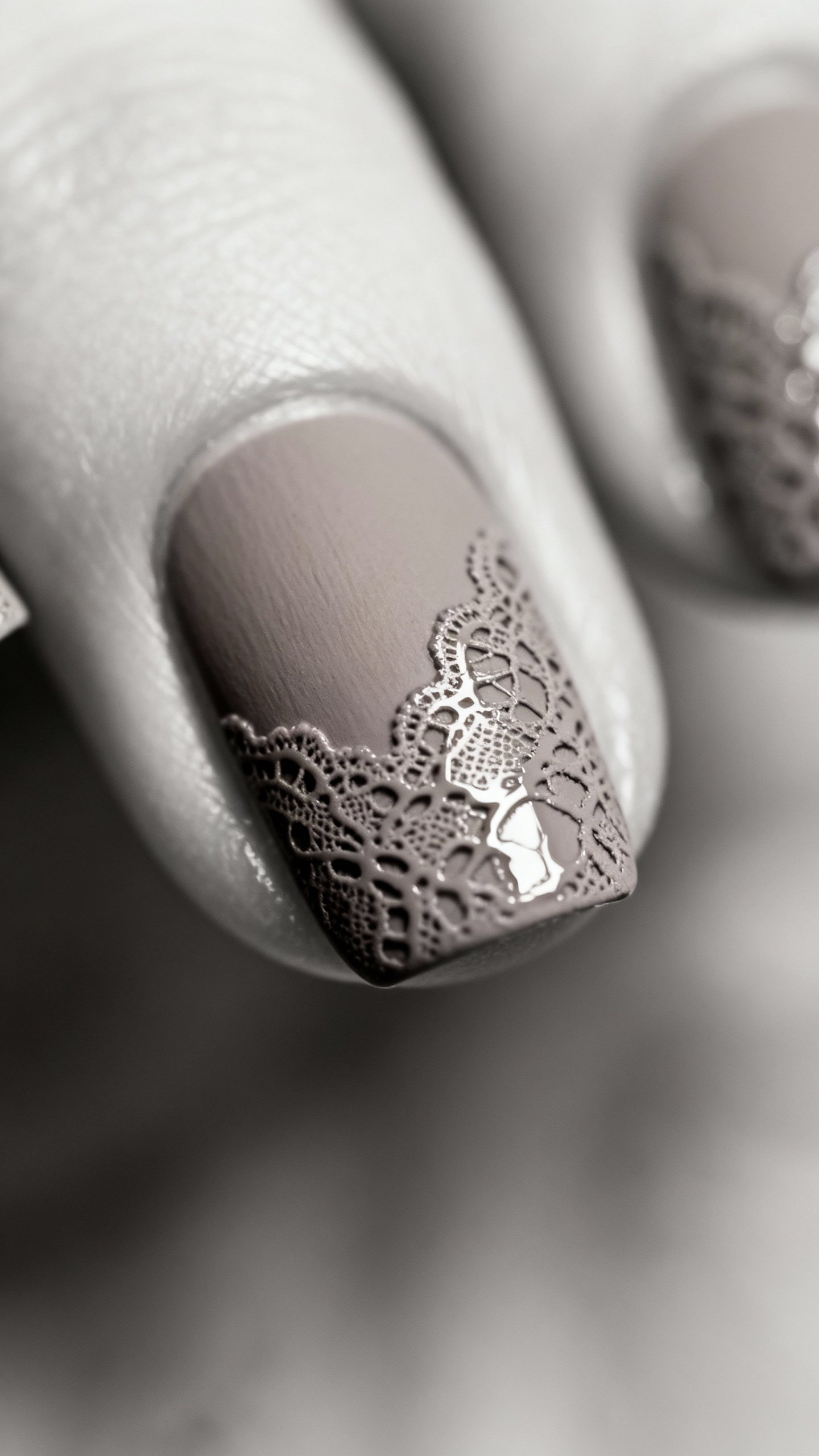 Macro shot short square nails, matte taupe base, glossy lace stamping