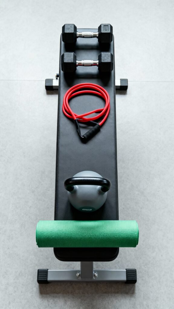 Overhead shot gym bench: dumbbells, loop band, kettlebell, rolled mat