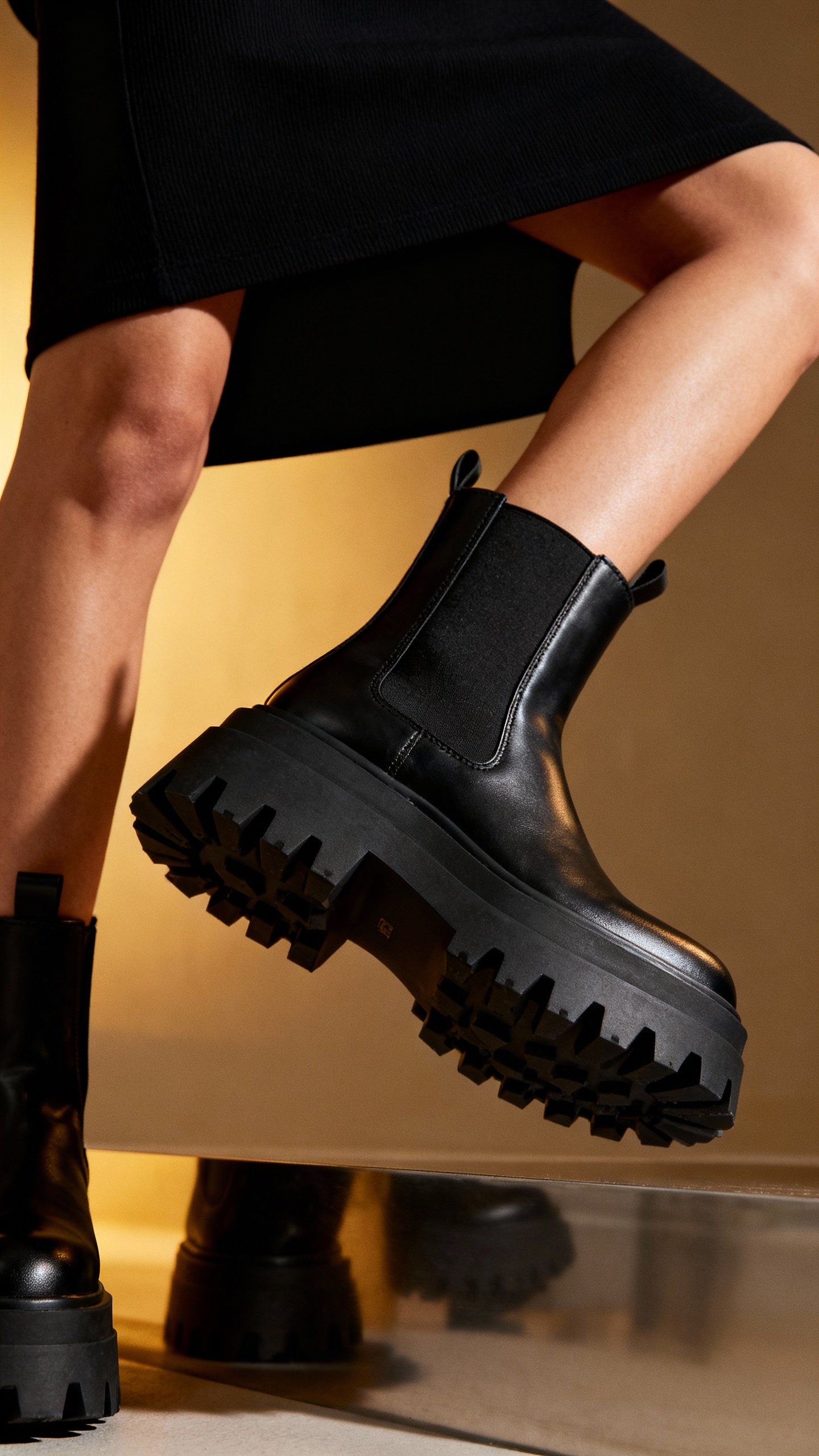 Closeup chunky lug-sole ankle boot with black mini dress