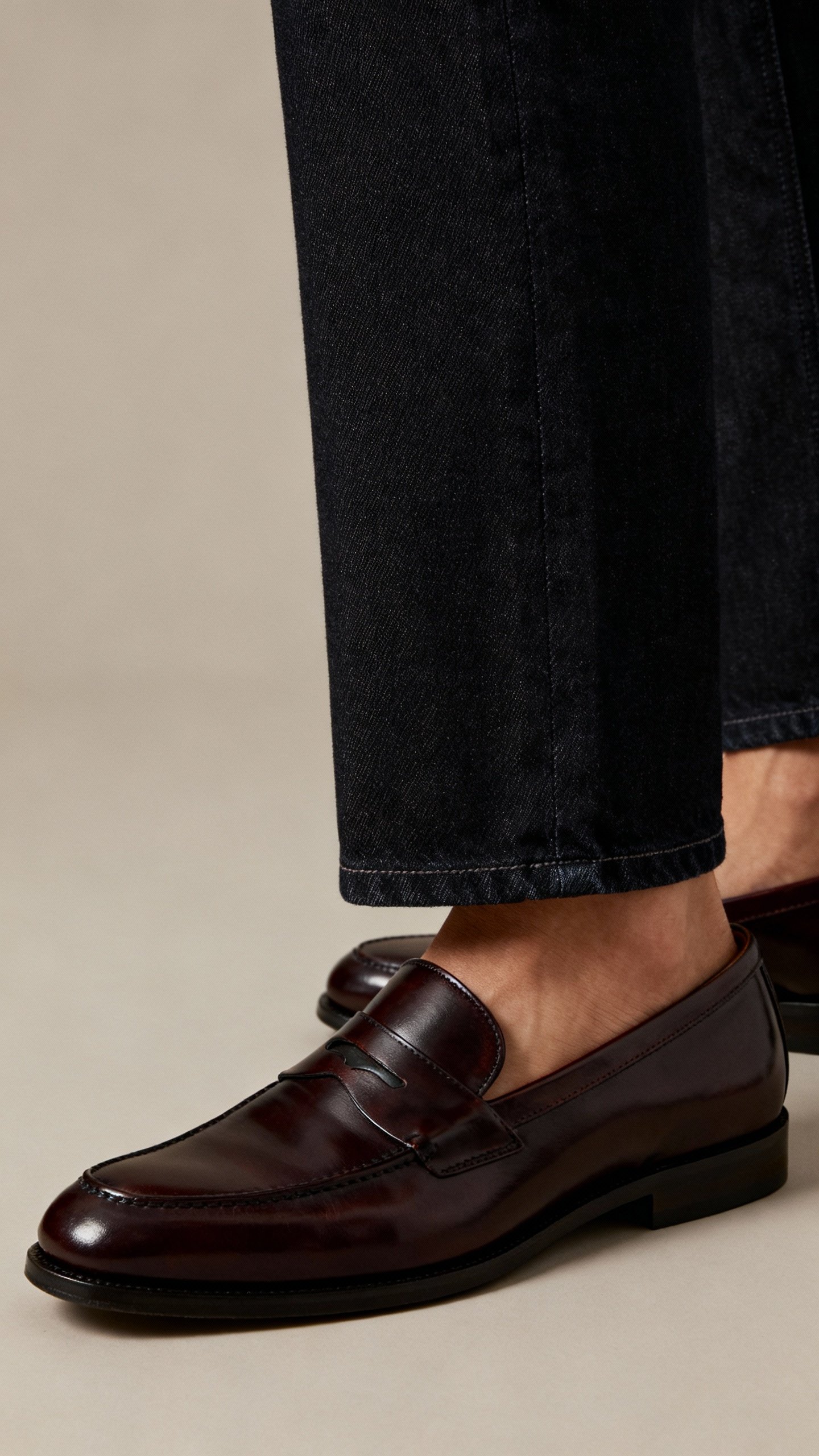 Dark straight jeans hemmed above ankle with polished loafers, detail shot