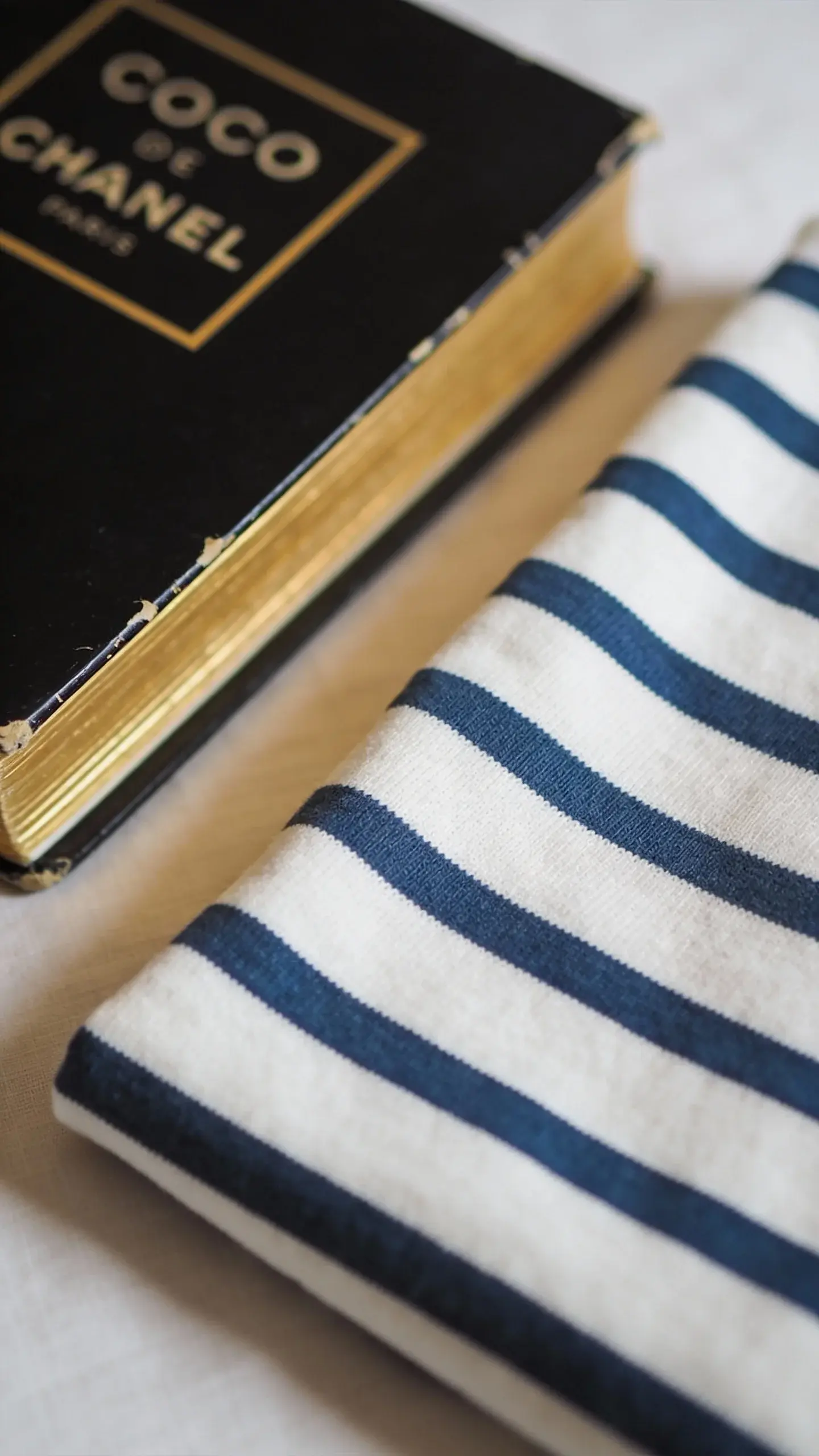 folded Breton stripe shirt beside Coco Chanel book