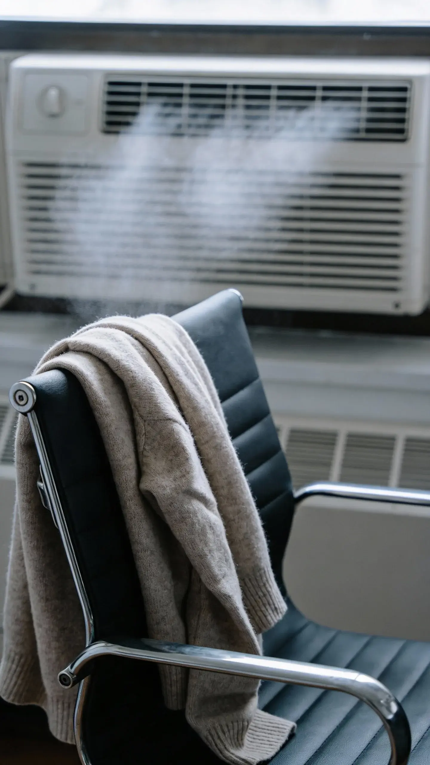 cashmere-cotton sweater draped over office chair, cold AC vent
