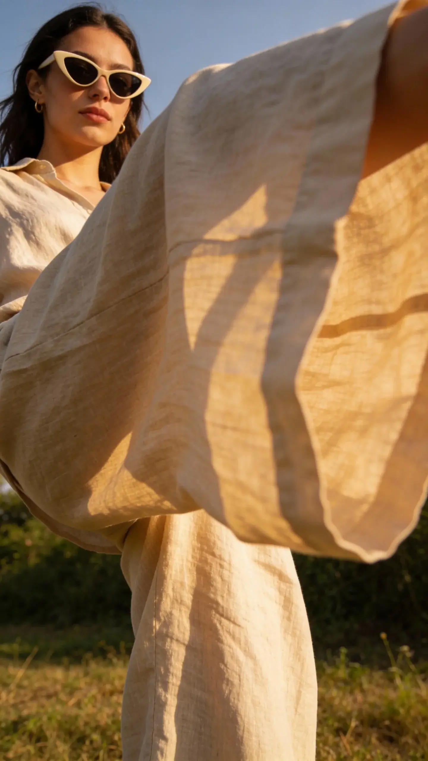 Wide-leg linen trousers in motion, sunlight, cat-eye sunglasses