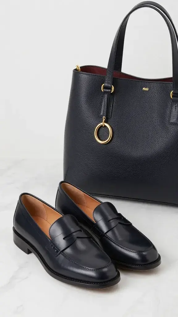 leather loafers, gold hoop earrings, structured tote on marble
