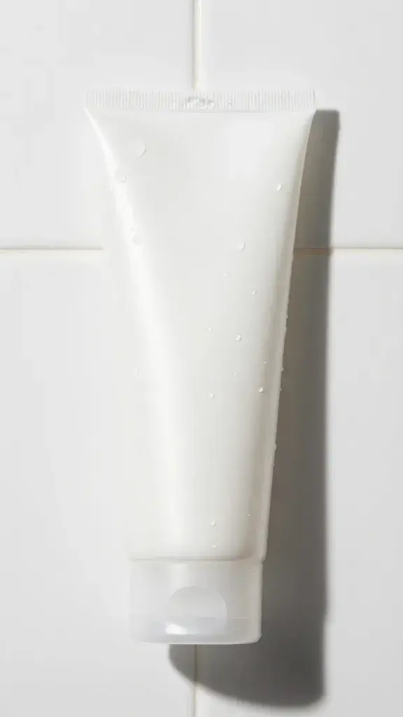 Gel cleanser and water droplets on white tile