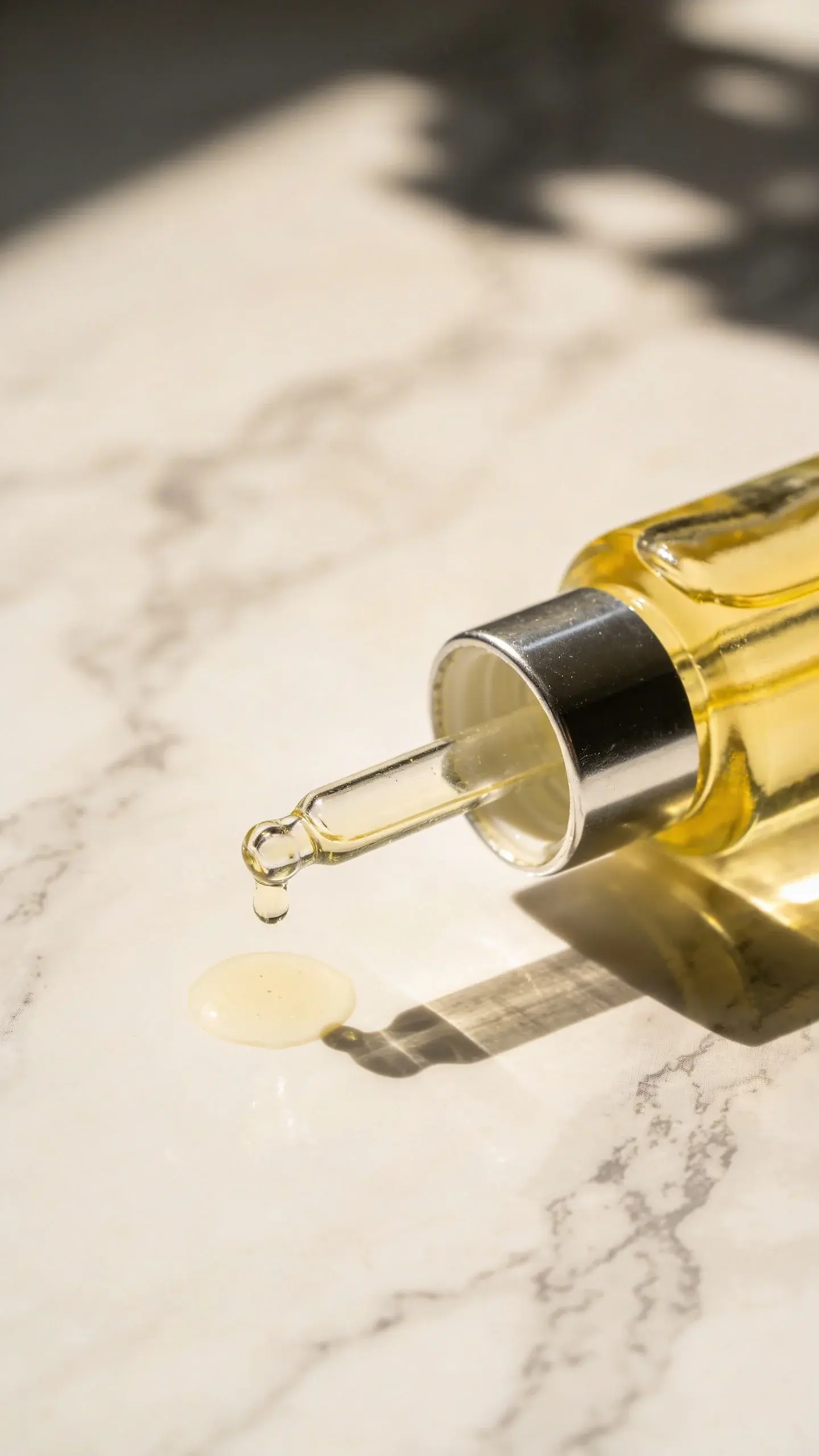 Vitamin C serum dropper on sunlit marble