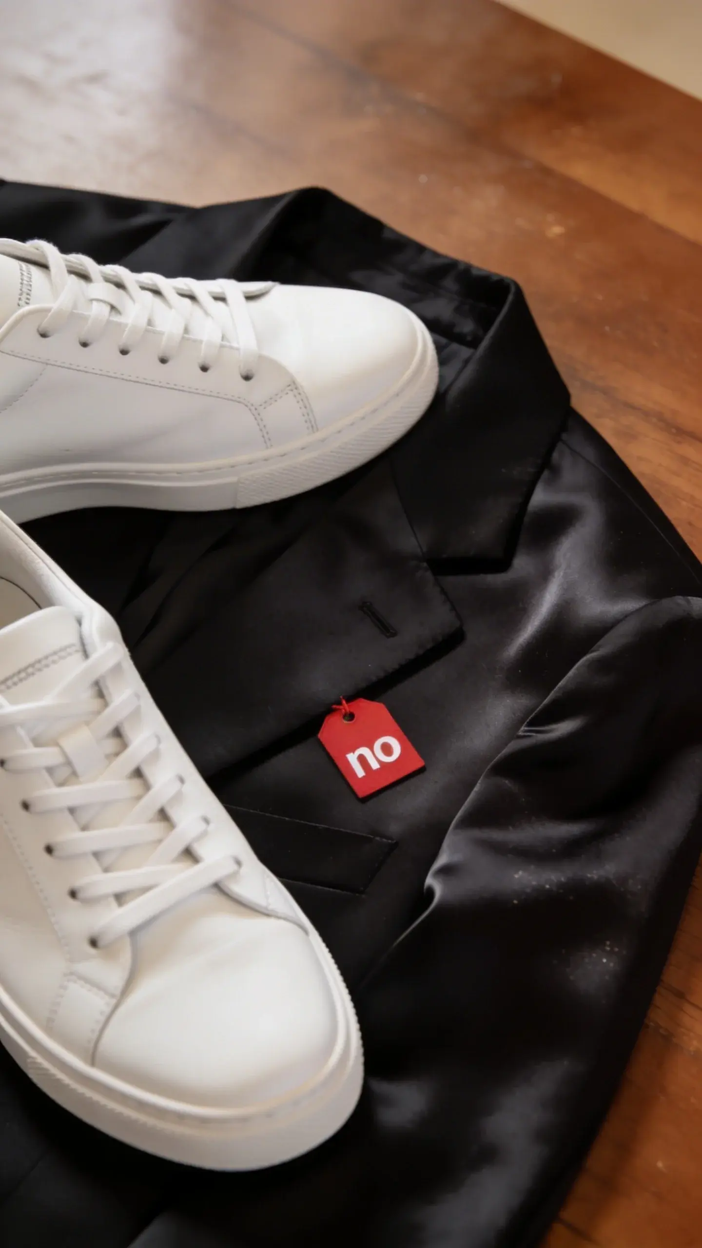sneakers beside silk blazer with red “no” tag