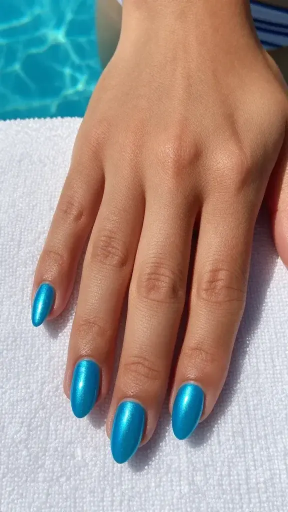 Top-down, ultra-realistic photo of a single hand resting on a textured white poolside towel beside a hint of turquoise pool water reflection. Nails are medium-length almond shape with a flawless electric aqua-blue gel base finished with high-shine blue chrome for a mirror-like, oceanic reflection. Each nail shows crisp, even curvature and a smooth, glassy surface that reflects subtle sky and pool highlights. Cuticles are neat and hydrated; skin tone is warm tan with a natural summer glow. Lighting is bright, natural midday sun with soft shadows, emphasizing the metallic sheen and reflective gradients over each nail. No nail art or embellishments, just pure chrome. Two glossy top-coat layers evident in the depth and clarity of reflection. Composition focuses tightly on the nails from a true top view, with a white ribbed swimsuit strap partially visible to enhance contrast. Color palette: vivid pool-blue, white, and sunlit neutrals. Photorealistic, 50mm lens look, high resolution, sharp focus on nails, minimal background distraction.
