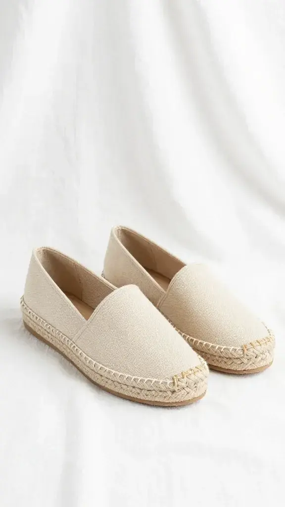 beige canvas espadrilles on white linen backdrop