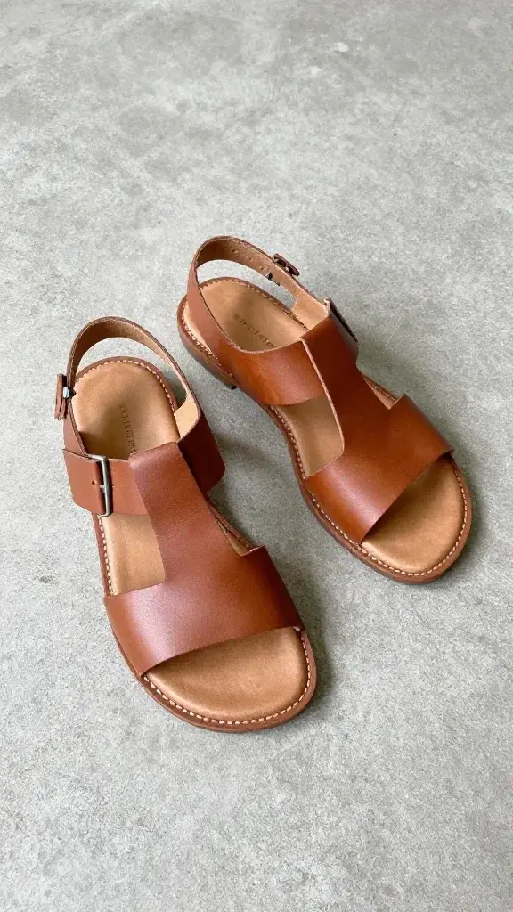 leather sandals with simple straps on concrete floor